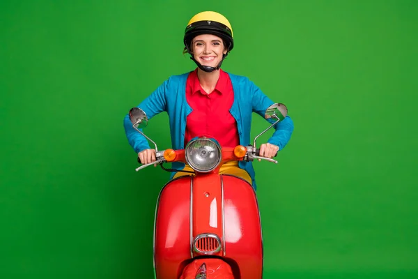 Foto van jong mooi glimlachen vrolijk goed humeur meisje dragen gele helm rijden rode motorfiets geïsoleerd op groene kleur achtergrond — Stockfoto