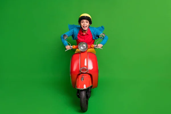 Foto seukuran penuh gadis cantik yang bersemangat gadis gila tersenyum mengendarai sepeda motor cepat merah yang terisolasi dengan latar belakang warna hijau — Stok Foto