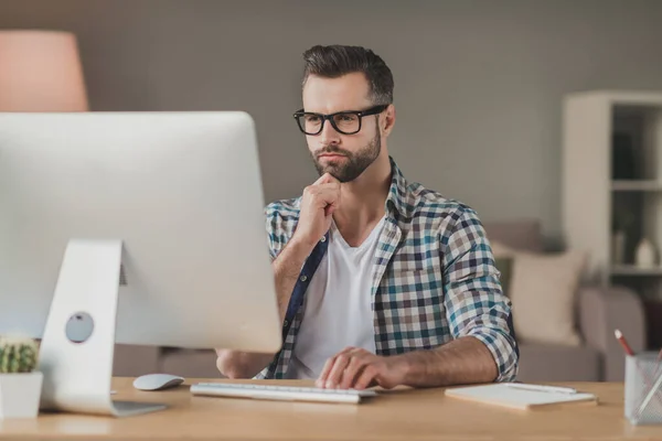 Photo of young man serious confident serious look think browse read computer distance work desk indoors — Stock fotografie