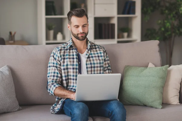 Fotografie de tineri frumos păr maro om de afaceri sta canapea acasă de lucru laptop tip raport purta tinuta casual — Fotografie, imagine de stoc