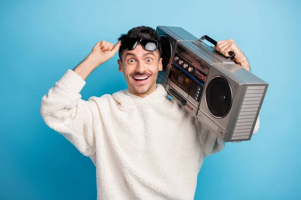Φωτογραφία πορτρέτο του ενθουσιασμένος άνθρωπος με γένια ανύψωση μέχρι γυαλιά κρατώντας boombox στον ώμο απομονώνονται σε παστέλ μπλε φόντο — Φωτογραφία Αρχείου