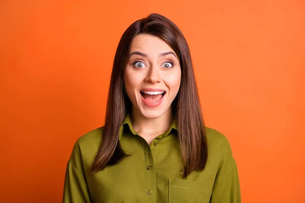 Foto di bella ragazza stupita guardare fotocamera faccia bocca sorriso lucido indossare camicia verde isolato colore arancione sfondo — Foto Stock