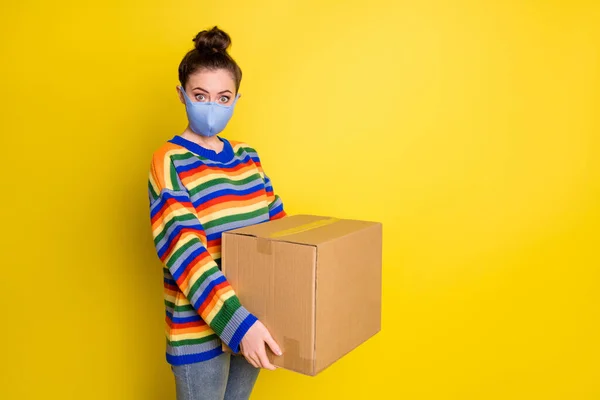 Zdjęcie brunetka dziewczyna trzymać ogromne pudełko nosić niebieską maskę od korony tęczy sweter spodnie izolowane na jasnożółtym tle kolor — Zdjęcie stockowe