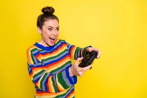 年轻迷人女人的侧面照片快乐积极的笑着玩电子游戏隔离黄色背景 — 图库照片