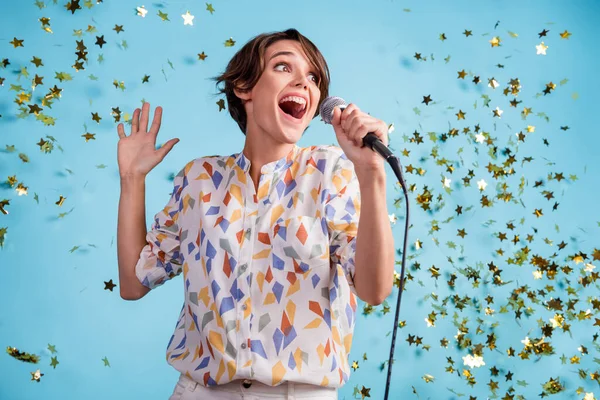 Fotografie mladé dívky ohromen těšit zpívat pop music serpentine hvězda létat izolované přes modré barvy pozadí — Stock fotografie