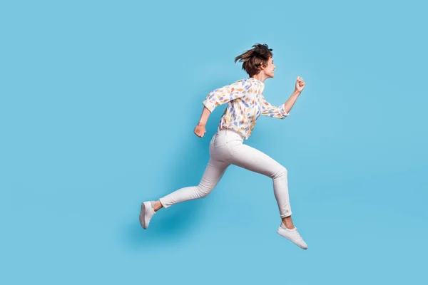 Teljes test profil oldalán fotó fiatal aktív lány boldog siet fuss ugrás eladó nézd üres tér elszigetelt kék szín háttér — Stock Fotó