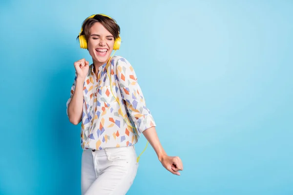 Foto von optimistischen hübsche junge Frau dace hören Headset Popmusik Notenpult Kopierraum tragen weiße Hosen isoliert auf blauem Hintergrund — Stockfoto