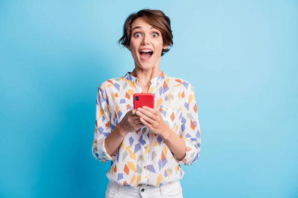 Foto de linda linda jovem senhora bonito espantado como segurar telefone isolado no fundo cor azul pastel — Fotografia de Stock