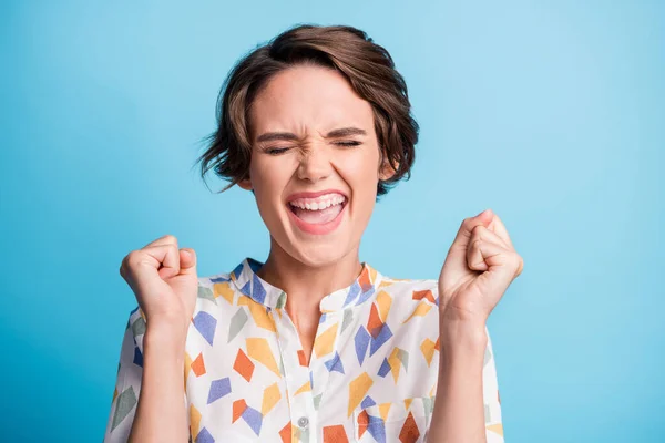 Foto av lycklig glad glad glad glad charmig ung dam höja knytnävarna säga ja seger isolerad på blå färg bakgrund — Stockfoto