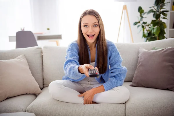 Retrato de chica adicta bastante alegre sentada en diván viendo el canal de conmutación de televisión en el apartamento de casa plana de luz interior — Foto de Stock