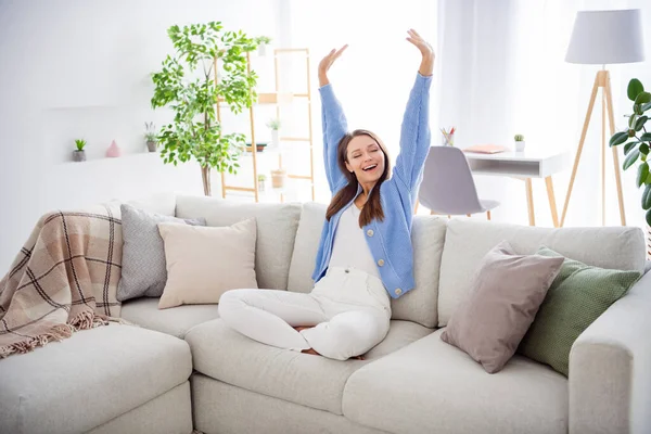 Porträtt av ganska drömsk glad flicka sitter på divan stretching gäspning i ljus platt hus lägenhet inomhus — Stockfoto