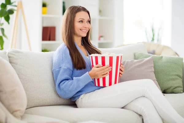 Profil Seitenansicht Porträt der schönen fröhlichen Mädchen sitzt auf Diwan essen Mais fernsehen in Licht flachen Haus Wohnung drinnen — Stockfoto