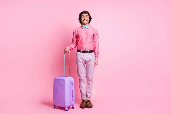 Foto em tamanho completo de morena bonito homem moderno bagagem de porão desgaste calças violetas óculos isolados no fundo cor-de-rosa — Fotografia de Stock