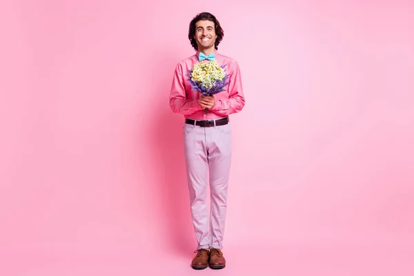 Full size foto di marrone capelli affascinante uomo tenere fiori di fioritura isolato su sfondo di colore rosa pastello — Foto Stock