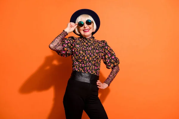 Foto de feliz sorrindo alegre positivo bom humor velha mulher posando na câmera isolada no fundo cor de laranja — Fotografia de Stock