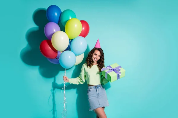 Foto de hermosa chica mantenga giftbox muchos globos usan jersey verde denim mini falda cono tapa aislado color azul fondo — Foto de Stock