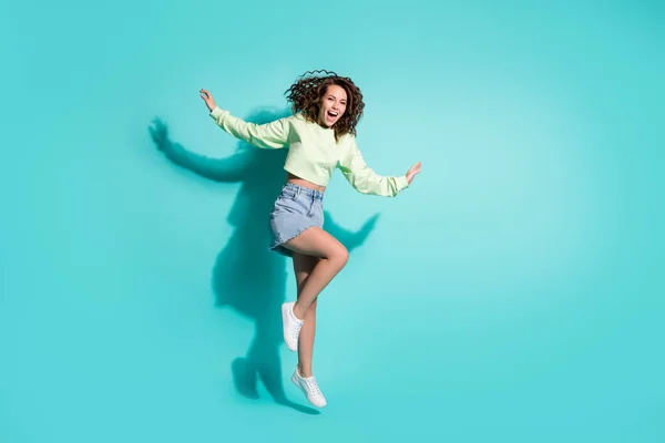Full längd kropp storlek foto av söt flicka dans skrattar hoppa på ett ben isolerad på pulserande teal färg bakgrund — Stockfoto