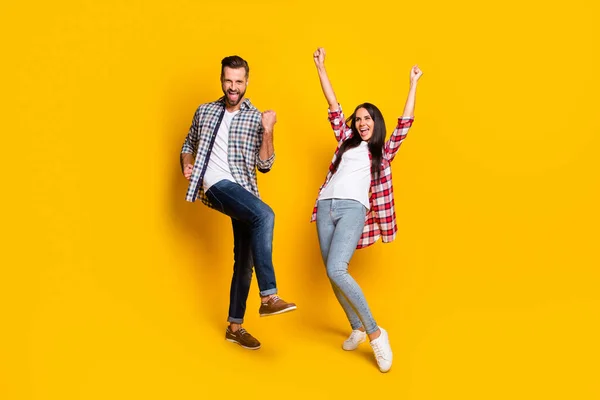 Foto retrato de larga duración de pareja loca emocionada celebrando aislado sobre fondo de color amarillo vivo —  Fotos de Stock