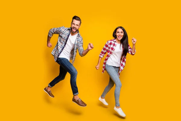 Photo portrait full body view of crazy couple jumping up running isolated on vivid yellow colored background — Stock Photo, Image