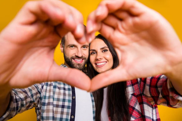 Ritratto fotografico di uomo e donna sposati che fanno cornice cuore con le mani vicino alla fotocamera isolato su sfondo giallo vivido — Foto Stock