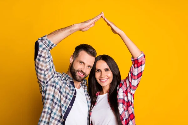 Portrait de beau couple joyeux montrant le toit sur la tête bonne vie isolé sur fond de couleur jaune vif — Photo