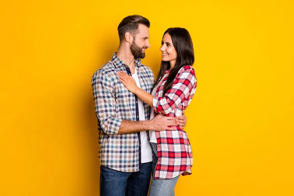 Profile side view portrait of attractive cheerful amorous couple embracing isolated over bright yellow color background — Stock Photo, Image