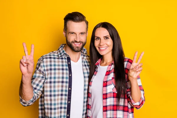 Портрет двох привабливих веселих людей, що показують v-знак ізольовано на яскраво-жовтому кольоровому фоні — стокове фото
