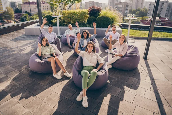 Porträtt av trevliga glada entreprenörer ledare partners sitter i påsen stolar lyssna högtalare företagskultur på taket utomhus — Stockfoto