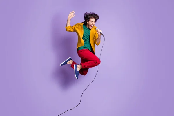 Fényképezés portré teljes test kilátás srác kiabáló ének mikrofon ugrás fel elszigetelt élénk lila színű háttér — Stock Fotó