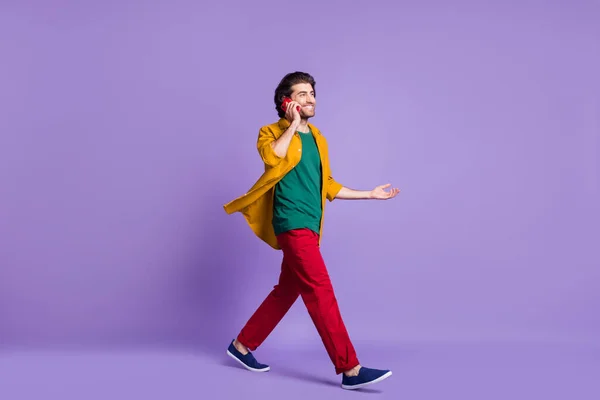 Fotoporträt in voller Länge von Mann telefoniert zu Fuß isoliert auf lebendigen violett gefärbten Hintergrund — Stockfoto