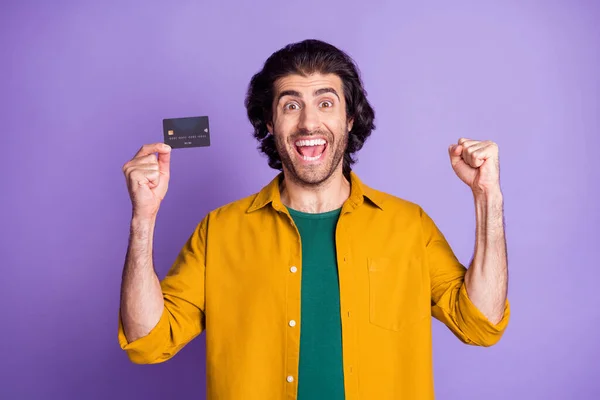 Фотопортрет прославления человека, держащего пластиковую карту в одной руке, изолированный на ярком фиолетовом фоне — стоковое фото