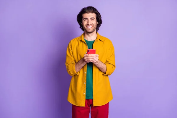 Foto de joven alegre positivo hombre feliz hombre masculino utilizando teléfono celular del teléfono inteligente aislado sobre fondo de color violeta — Foto de Stock