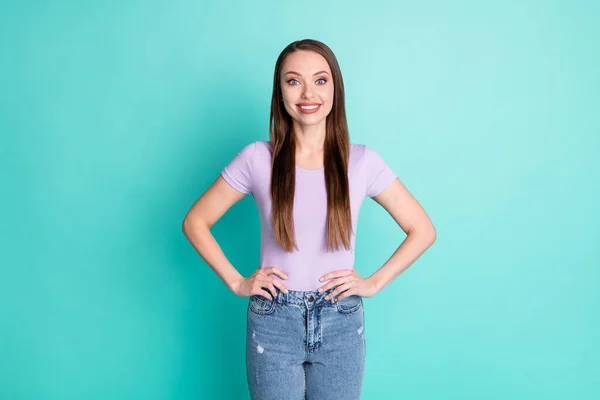 Foto retrato de chica con el pelo largo sonriente poner las manos en la cintura aislado en fondo de color verde azulado vibrante —  Fotos de Stock