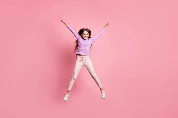 Foto de longitud completa de niño despreocupado niña saltar levantar manos aisladas sobre fondo de color pastel —  Fotos de Stock