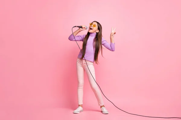 Teljes hosszúságú fotó a kisgyerek lány popsztár ének mikrofon viselet lila pulóver elszigetelt pasztell szín háttér — Stock Fotó
