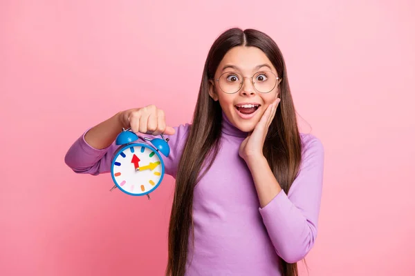 Foto de criança pequena menina surpreendida segurar relógio toque mão face desgaste violeta jumper isolado sobre fundo cor pastel — Fotografia de Stock