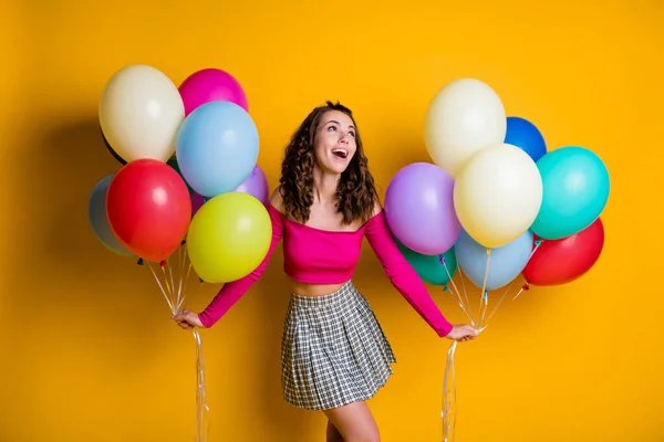 Ritratto foto di divertente femmina sognante adolescente guardando su indossando casual off-top gonna a scacchi tenendo palloncini d'aria isolati su vivido sfondo di colore giallo — Foto Stock