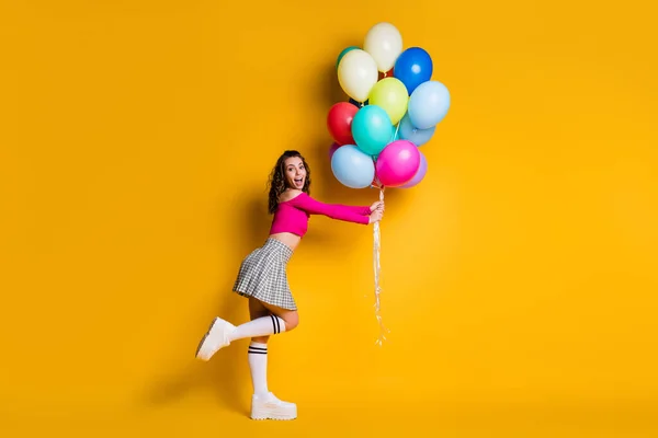 Ganzkörpergröße Foto von überrascht beeindruckt junge Mädchen mit Luftballons lächeln fröhlich erstaunt isoliert auf leuchtend gelben Farbhintergrund — Stockfoto