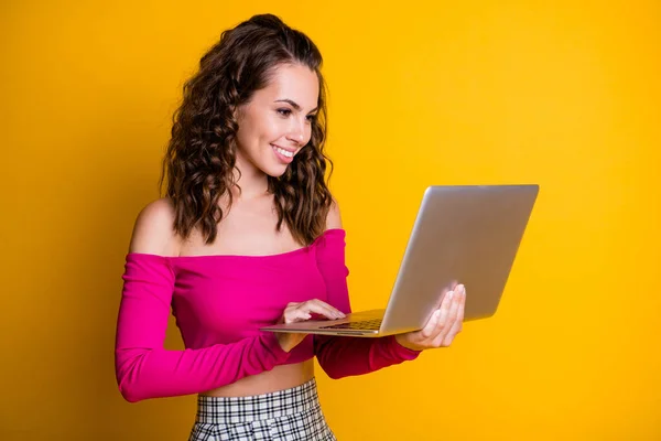 Foto de bonito doce senhora encaracolado penteado segurar netbook brilhante radiante sorriso cheque caixa de correio desgaste rosa top despido ombros saia isolado cor amarela fundo — Fotografia de Stock