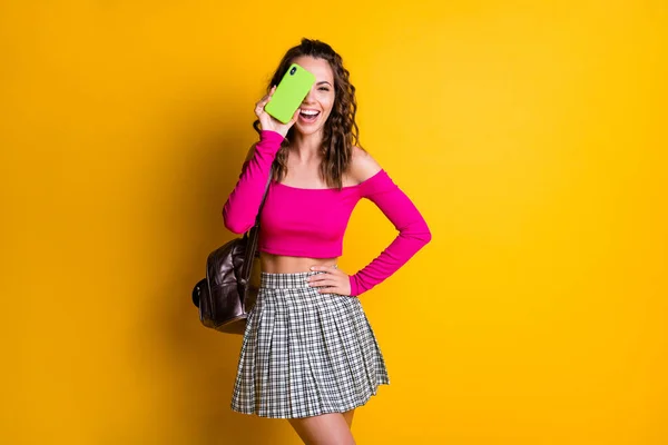 Foto de la señora encantadora peinado ondulado mantener el teléfono cerrar los ojos riéndose boca abierta desgaste bolso rosa top sin ropa hombros mini falda aislado color amarillo fondo — Foto de Stock