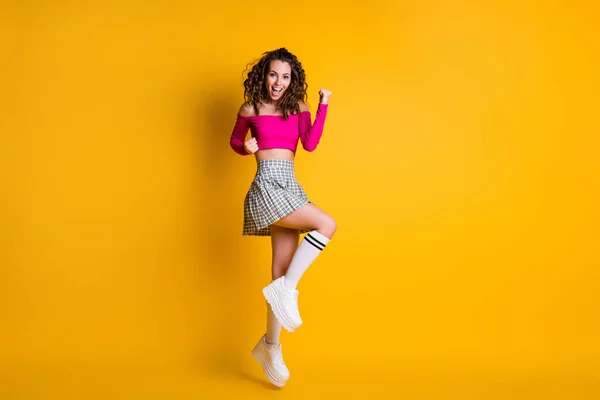 Full body size photo of lovely cute lady wavy hairdo raise arms fists open mouth jump wear pink cropped top uncovered shoulders mini-saia branco tênis isolado cor amarela fundo — Fotografia de Stock