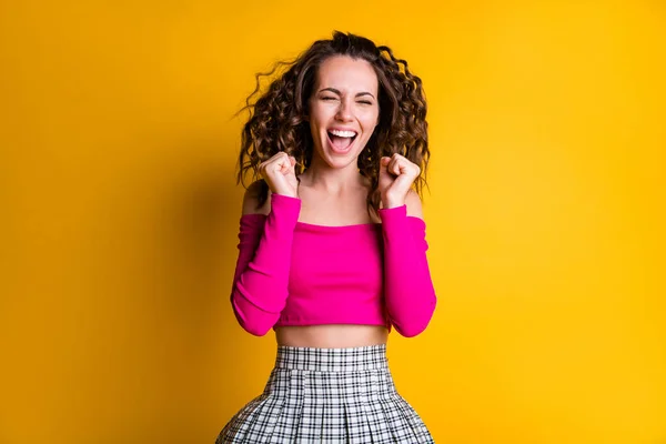Foto retrato de mulher animada segurando punhos para cima gritando vestindo rosa saia xadrez cut-top isolado no fundo de cor amarelo brilhante — Fotografia de Stock
