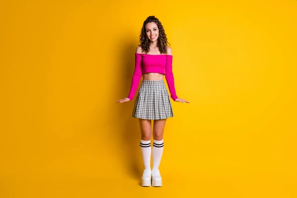 Foto in voller Größe von charmanten wunderschönen freundlichen lockigen Dame tragen rosa nackten Schultern Top karierten Minirock weiße lange Socken Schuhe isoliert lebendige gelbe Farbe Hintergrund — Stockfoto