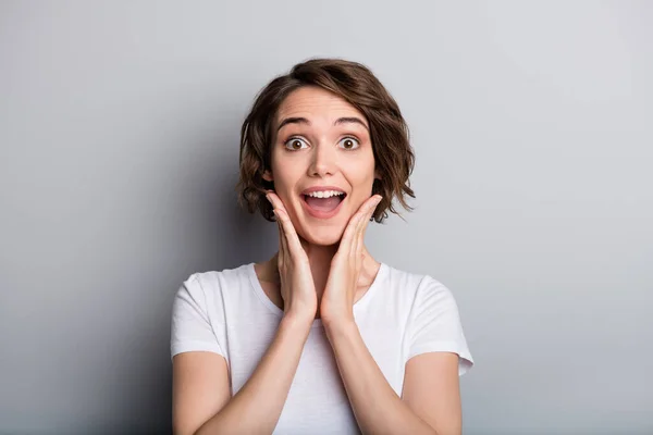 Ritratto di giovane donna sorridente sorridente felice ragazza sguardo femminile in fotocamera tenere le mani sulle guance isolate su sfondo di colore grigio — Foto Stock