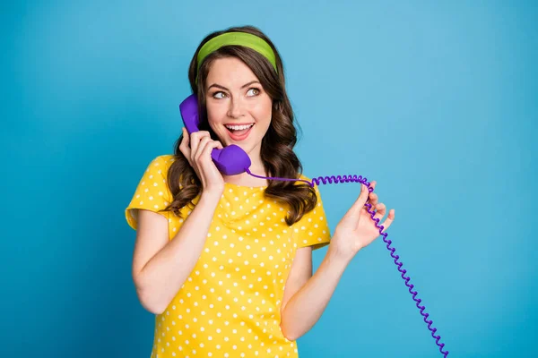 パステルカラーのライトブルーの背景に隔離された紫色の電話のワイヤーを保持している女性の写真 — ストック写真