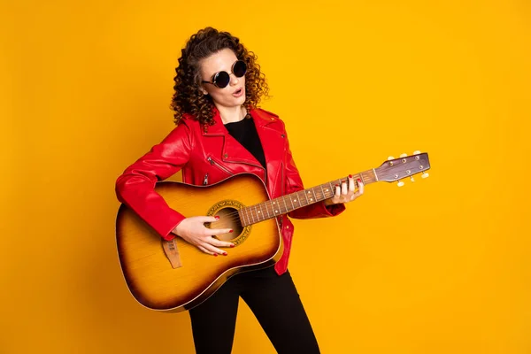 Portret van aantrekkelijke getalenteerde populaire golvende haren meisje spelen bas gitaar geïsoleerde heldere gele kleur achtergrond — Stockfoto