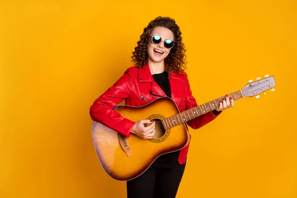 Portret van aantrekkelijke vrolijke beroemde golvende harige meisje spelen gitaar zingen geïsoleerde helder gele kleur achtergrond — Stockfoto