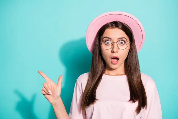 Foto de surpreendido jovem menina indicador apontar espaço vazio dedo para anúncios promocionais isolados sobre fundo cor teal — Fotografia de Stock