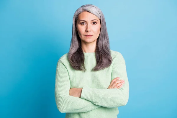 Foto do aposentado senhora idosa cruzou os braços olhar sério câmera desgaste verde pulôver isolado azul cor fundo — Fotografia de Stock