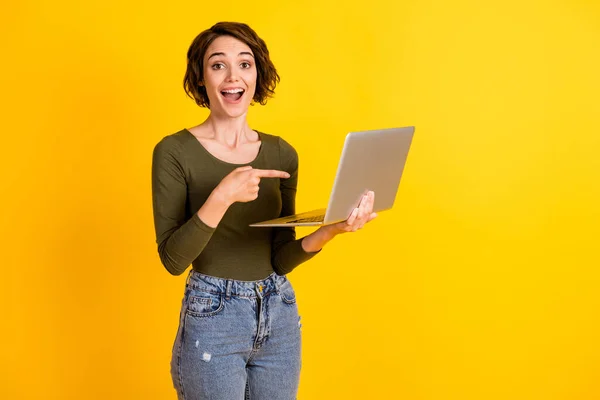 Señorita positiva dedo índice portátil elegir decidir concepto de promoción desgaste jersey denim aislado sobre brillo amarillo color fondo — Foto de Stock